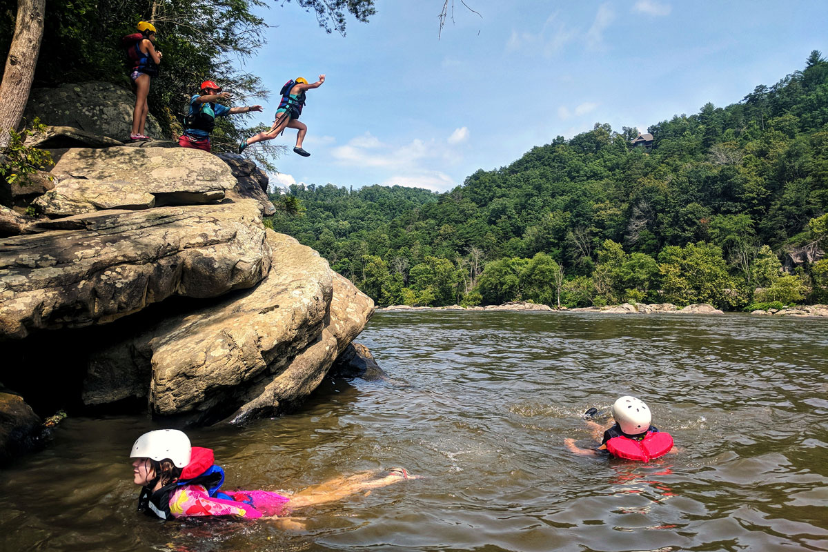 Campers leap into the river